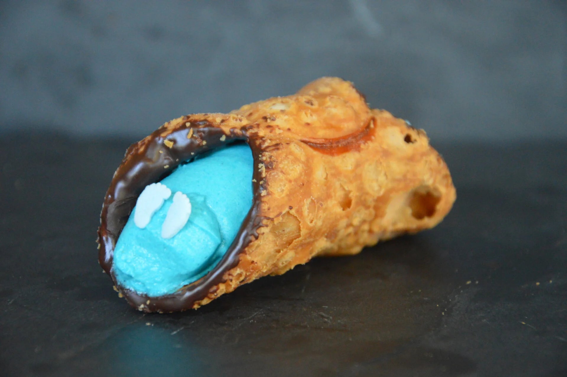 Heerlijk Cannoli Geboorte J/M gevuld met romige witte chocolade creme, versierd met blauwe voetjes.