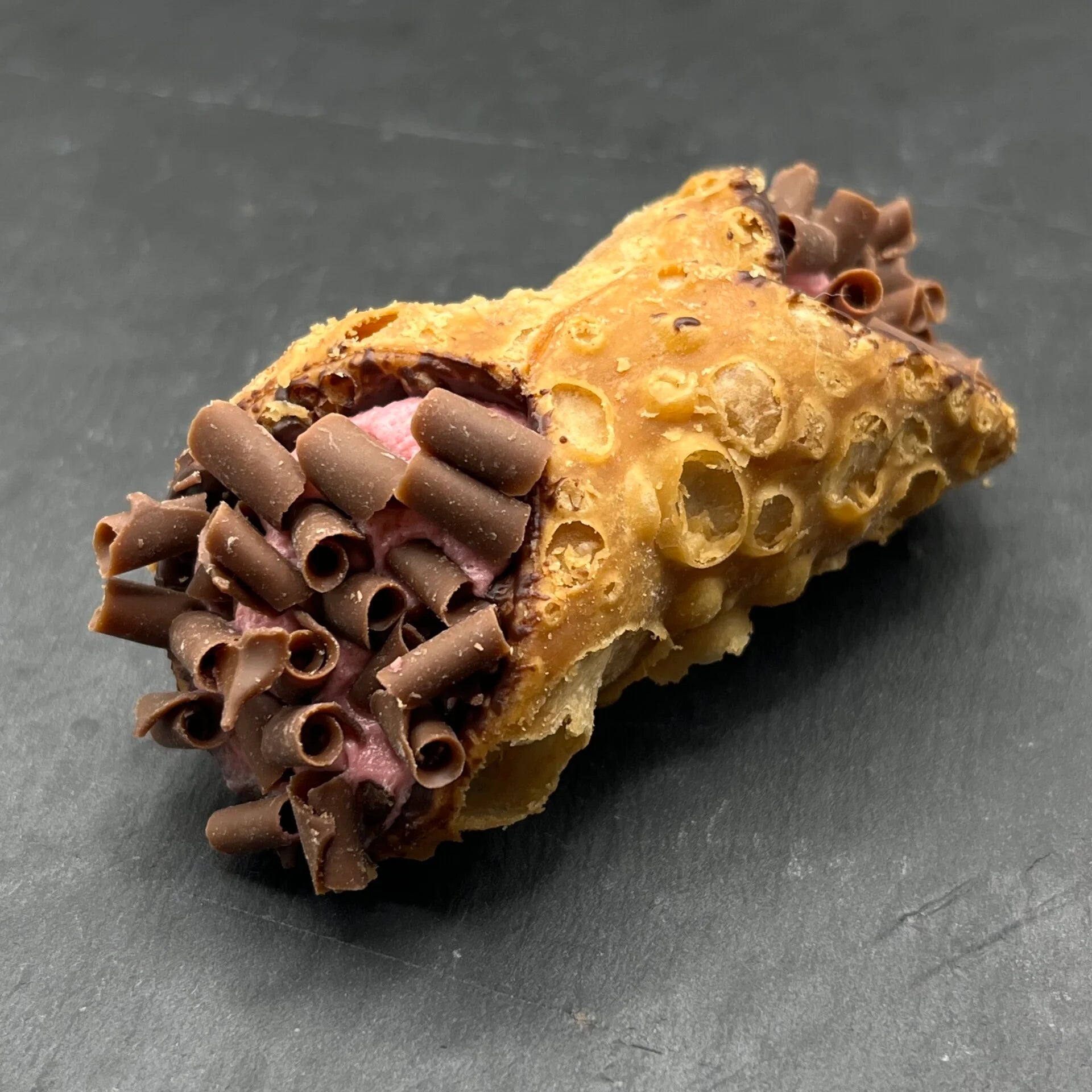 Geniet van onze Cannoli Lampone - Framboos, ambachtelijk gevuld met romige framboos-vulling, perfect bij een bakje koffie.